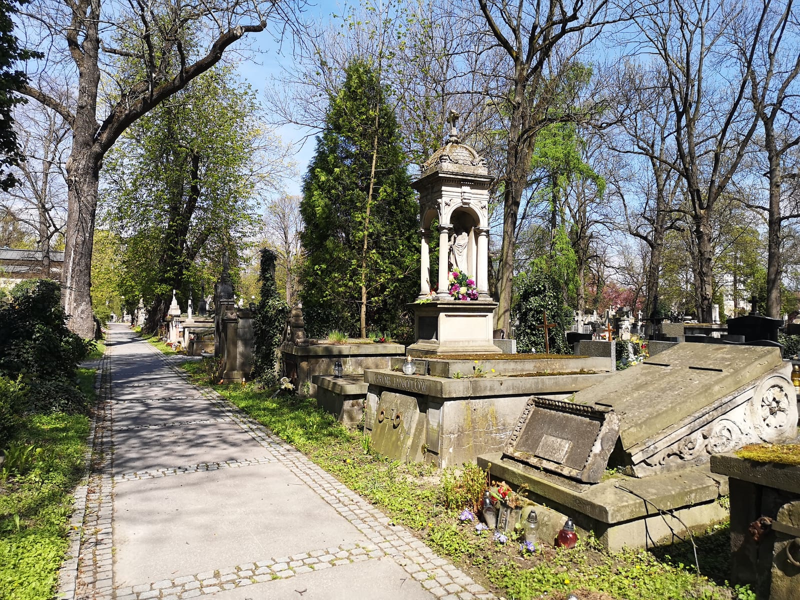 A weathered 19th-century gravestone in a Polish cemetery with carved family name and dates.
